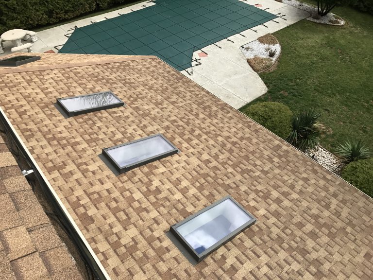 Professional roofing and siding contractor installing asphalt shingles.